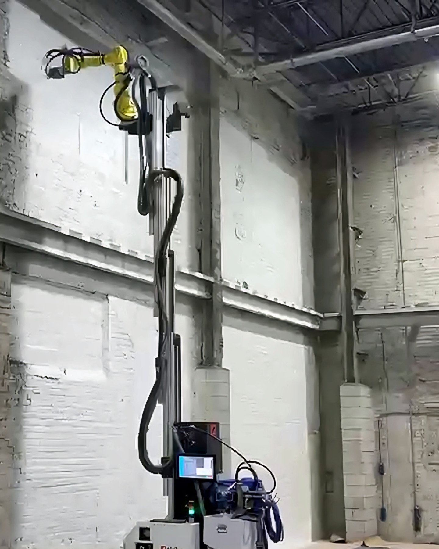 Okibo EG7+ spraying a white coat at the top of a 24 ft masonry wall